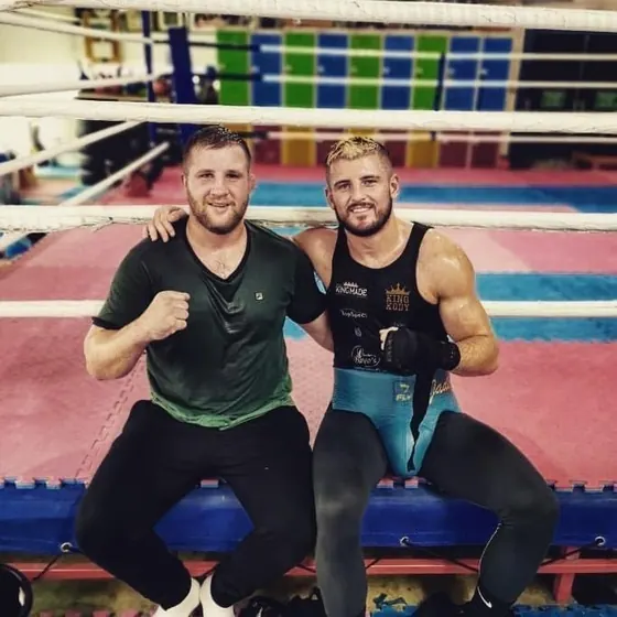 Courtney sitting ringside with a teammate