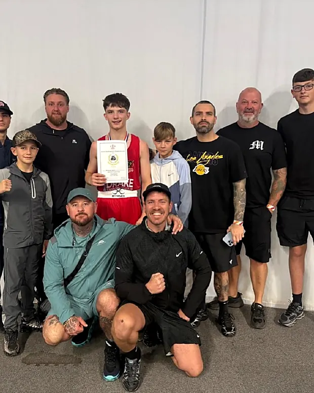 Team with a junior boxer holding a certificate at Intense Boxing