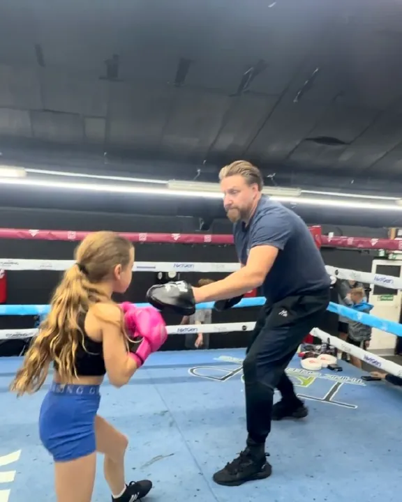 Young boxer on the pads with a coach in the ring at Intense Boxing